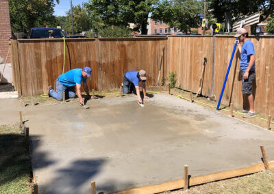 Men smoothing fresh concrete pour
