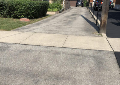 Sealed black asphalt next driveway to unsealed one